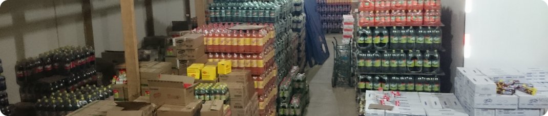 Depósito da MASA com caixas de produtos organizadas em prateleiras e paletes